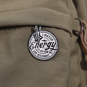 Retro black and white enamel skull hand badge with I MATCH Energy text on canvas