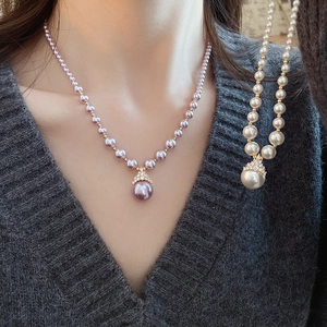 Détail de parure collier en perles plaqué or avec pendentif goutte et cristaux