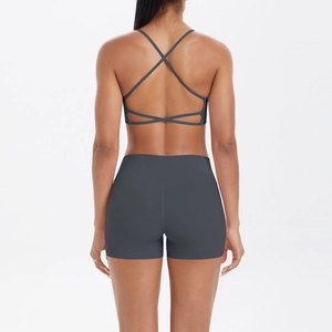 Détail d'un ensemble de yoga gris foncé avec bretelles croisées et short taille haute