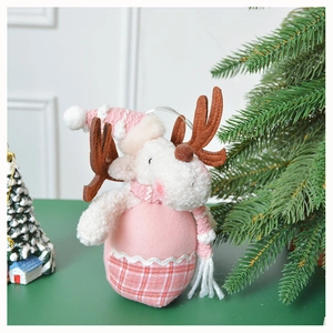 Close-up of pink reindeer plush ornament with knit texture and scarf for Christmas