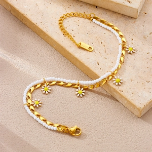 Double-layered daisy anklet in stainless steel with white beads on a stone background