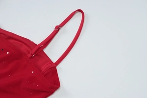 Close-up of red sequin dress featuring adjustable thin straps and shimmering silver sequins