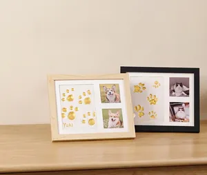 Detailed view of DIY pet paw print memorial frame with golden imprint and photo slots
