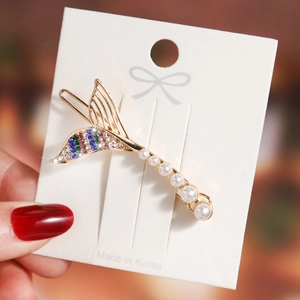 Detailed shot of mermaid tail hair clip with colorful crystals and white pearls