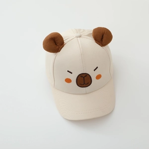 Detailed embroidery of a cute bear face on a cream cotton kids baseball sun hat
