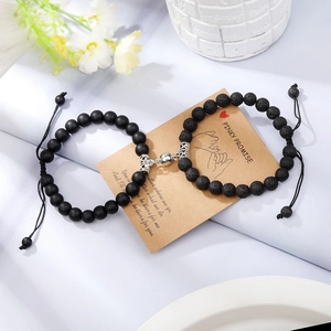 Close-up of magnetic natural stone bracelets for couples on a pinky promise card