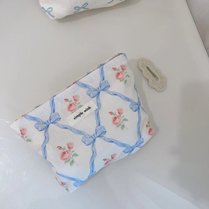 Détail de la trousse de maquillage florale avec rubans bleus et motifs roses