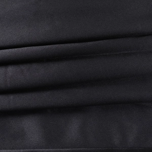 Gros plan détaillé du tissu en satin noir plissé offrant une brillance élégante