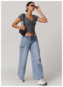 Full view of women's grey V-neck cropped yoga top and distressed wide-leg jeans