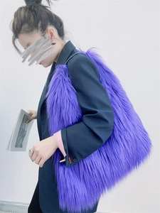 Detailed view of a purple plush tote bag with long faux fur texture held by a model