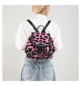 Pink leopard print backpack with silver rivets and three front buckle pockets shown on model