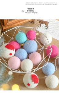 Detail of colorful wool felt balls with hanging loops in a decorative metal basket