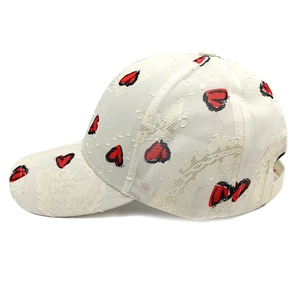 Detail of white baseball cap with heart pattern and lace texture on a curved brim