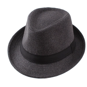 Détail d'un chapeau fedora gris avec ruban noir sur un fond blanc neutre