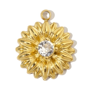 Macro detail of a gold sunflower pendant with a clear sparkling gemstone center