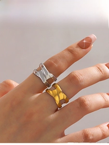 Close-up of gold and silver minimalist crossed geometric rings on fingers
