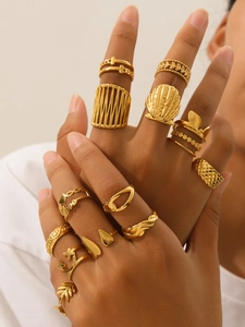 Close-up of stacked 18k gold plated stainless steel rings with shell and love motifs