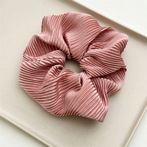 Detail of dusty pink oversized scrunchie with silky pleated texture and soft luster