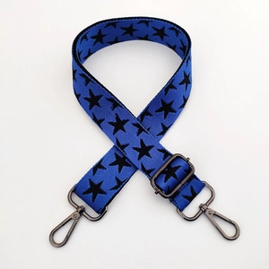 Close-up of blue wide adjustable shoulder strap with black star patterns and metal hooks