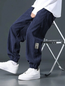 Close-up of navy blue corduroy texture and decorative side label on cargo pants