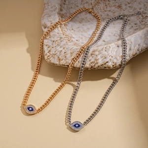 Detail of gold and silver evil eye necklaces with cubic zirconia and blue enamel