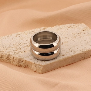 Détail de la bague double couche en métal argenté sur pierre avec fond en tissu beige