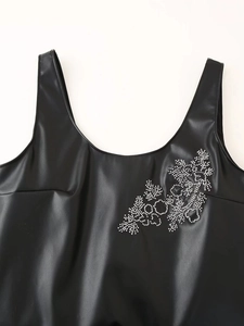 Detail of black PU leather tank dress with silver rhinestone floral embellishment