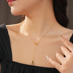 Close-up of golden gourd necklace with tiger eye stone and zircons on model neck