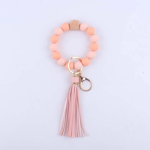 Pink silicone bead keychain bracelet with a wooden bead and matching leather tassel