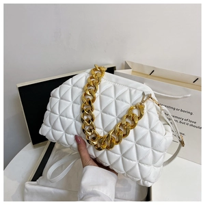 Detail of white quilted shell bag featuring thick gold chain strap and soft leather texture