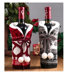 Detailed close-up of red and grey knitted Christmas wine bottle covers with pom-poms