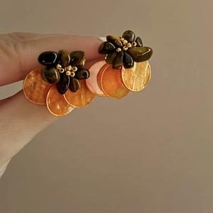 Detailed view of tiger eye stone flower earrings with hanging amber shell discs