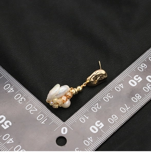 Detailed measurement showing 4cm length of pearl earring on black textured background