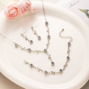French style silver rose jewelry set with necklace bracelet and earrings in a ceramic dish