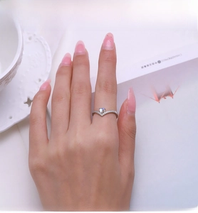 Macro detail of V-shaped S925 silver ring with heart moonstone and pavé zircon on hand