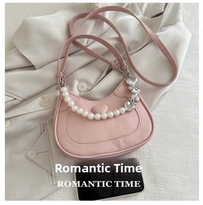 Pink crescent handbag with pearl handle, silver heart chain and compact interior space