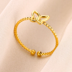 Detailed macro view of a gold-plated butterfly open ring on elegant pink fabric