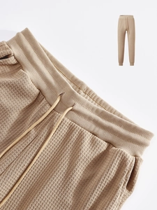 Detailed macro view of khaki waffle knit fabric and drawstring on men's casual joggers