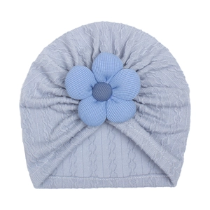 Close-up of baby knit beanie in hazy blue featuring jacquard texture and floral detail