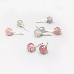 Detailed close-up of 5mm round strawberry crystal and moonstone stud earrings in silver