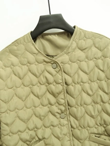 Detailed view of heart-shaped quilting and snap buttons on this sage green jacket