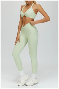 Macro detail of mint green yoga sports bra and high-waisted crossover leggings set