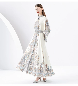 Detail of paisley print maxi dress with stand collar and flared sleeves with waist belt