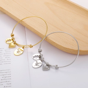 Detailed shot of gold and silver expandable bangles with heart and silhouette charms