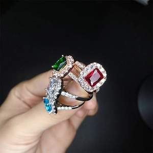 Macro view of colorful gemstone rings with vibrant square stones and diamond halos