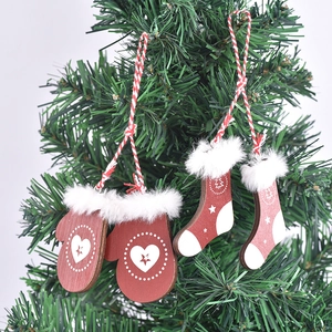 Red and white wooden Christmas glove and sock ornaments hanging on a decorated tree