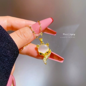 Handheld view of a gold titanium steel fox necklace with opal stone and diamond accents