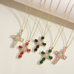 Detail of five gold cross necklaces with colorful zircon stones and religious charms