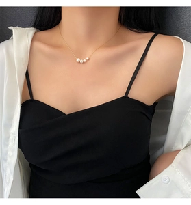 Detail of natural pearls on gold titanium steel necklace worn on a female neck