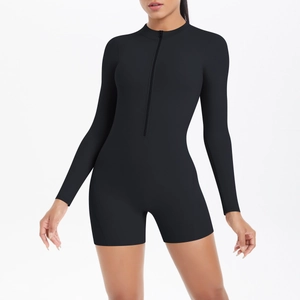 Close-up of the front zipper detail on a black long-sleeve athletic one-piece yoga bodysuit